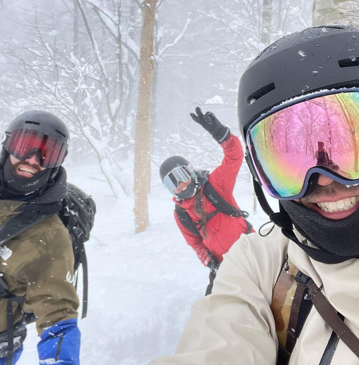 A group of friends skiing through the snowy trees